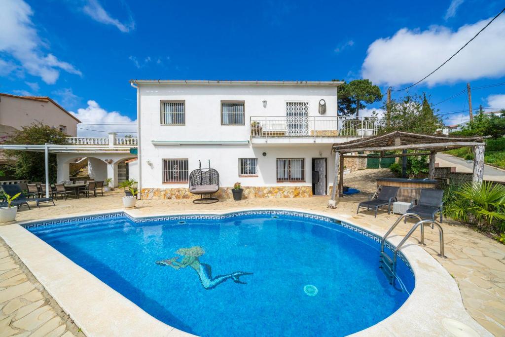 a swimming pool in front of a house at Casa Felic 12 personen, familiehuis met hottub in Lloret de Mar