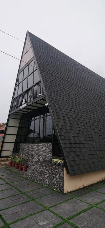 a building with a black roof with plants at Eden Cottage in Cochin