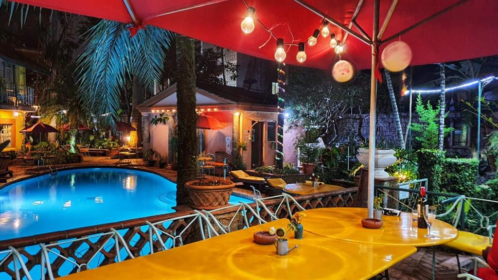 uma piscina com mesas e um guarda-sol em Woodmere Grand Hotel & Serviced Apartments em Nairobi