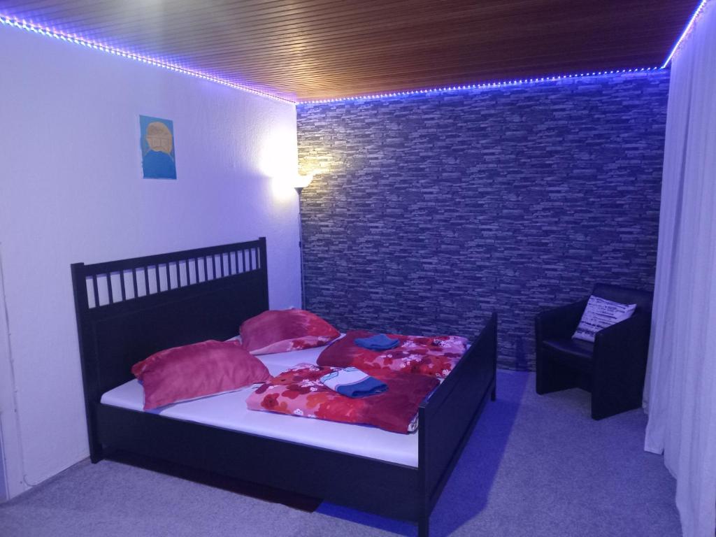 ein Schlafzimmer mit einem Bett, einem Stuhl und einer Ziegelwand in der Unterkunft 3 Bedroom Cozy Apartment 30min zu Hamburg in Buchholz in der Nordheide