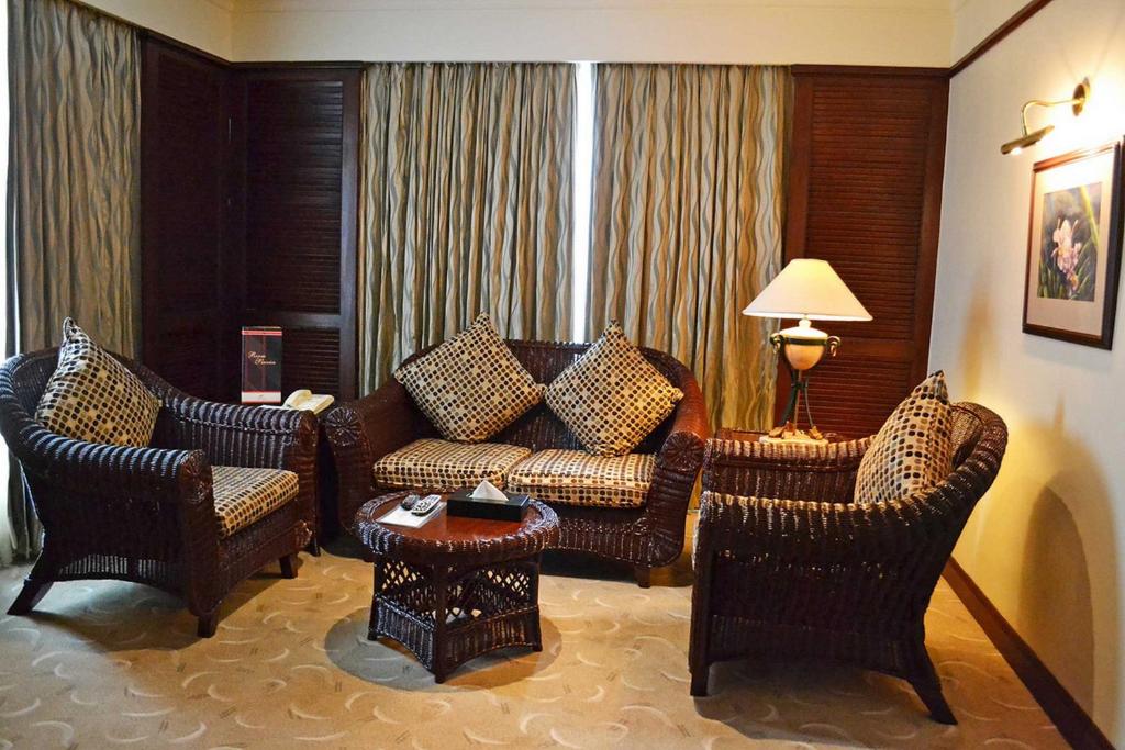 a living room with a couch and two chairs at Waterfront Airport Hotel and Casino in Mactan