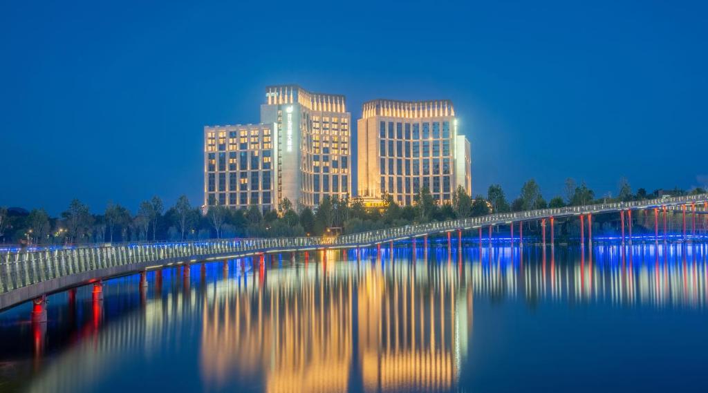 a view of a city with a bridge over a river at New Century Grand Hotel Zunyi in Zunyi