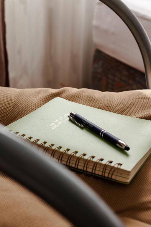 a pen sitting on top of a notebook on a chair at Villa Diana WestEnd in Frankfurt