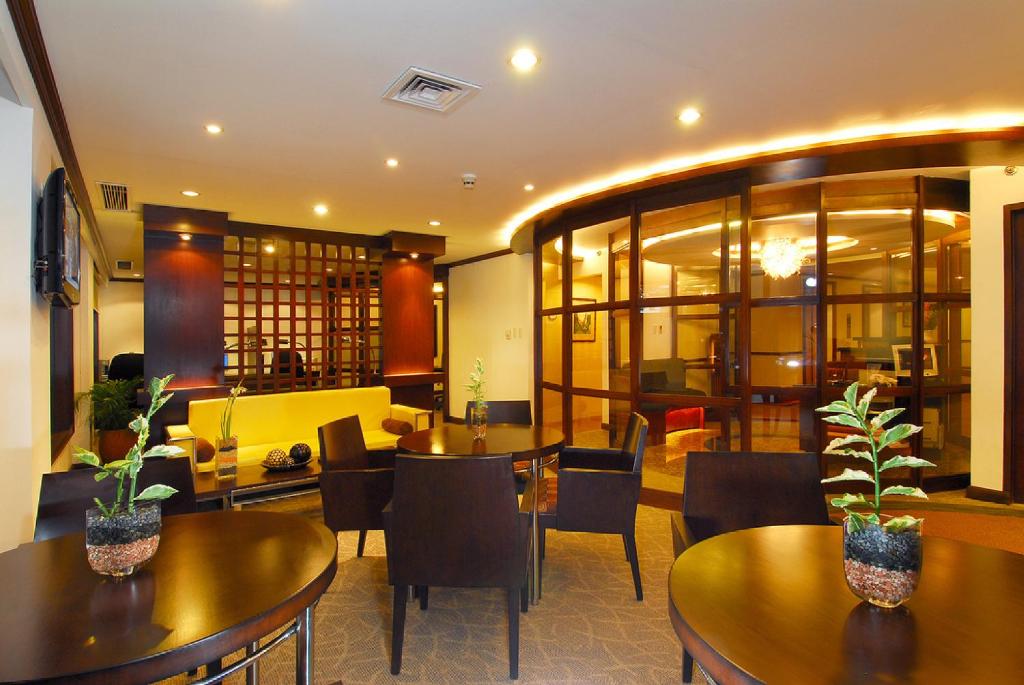 a restaurant with tables and chairs and a lobby at Waterfront Airport Hotel and Casino in Mactan