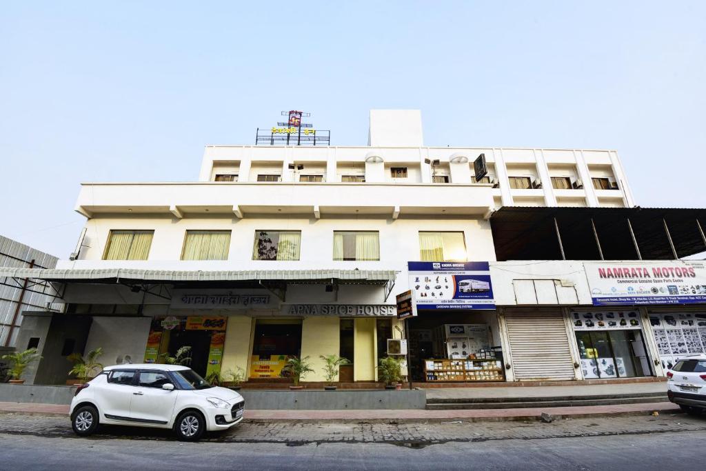 Un coche blanco aparcado delante de un edificio en Devanshi Inn By Glitz Hotels, en Navi Mumbai