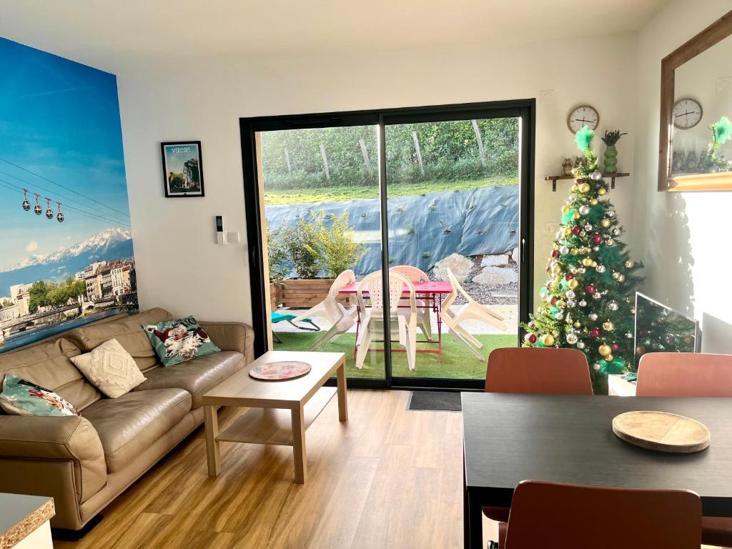 ein Wohnzimmer mit einem Weihnachtsbaum und einer Couch in der Unterkunft Gîte Le Parmé' nid 3 lits parking privé terrasse in Beaucroissant