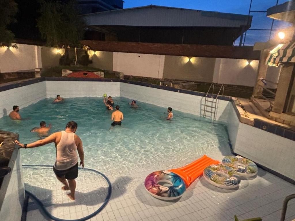 un groupe de personnes dans une piscine dans l'établissement Farm stay yalgaar, à Bhundsi
