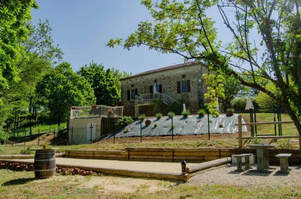ein altes Steingebäude mit einem Zaun davor in der Unterkunft Maison d'hôtes in Grézels