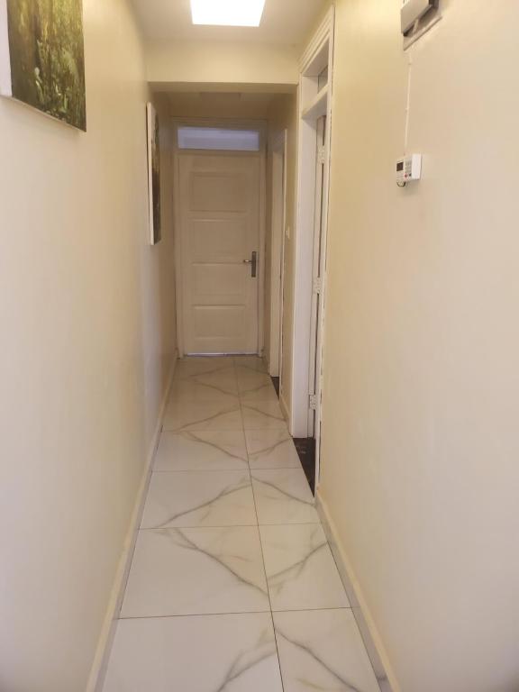 ein Flur mit einer Tür und einem Fliesenboden in der Unterkunft Noah's Ark in Kampala