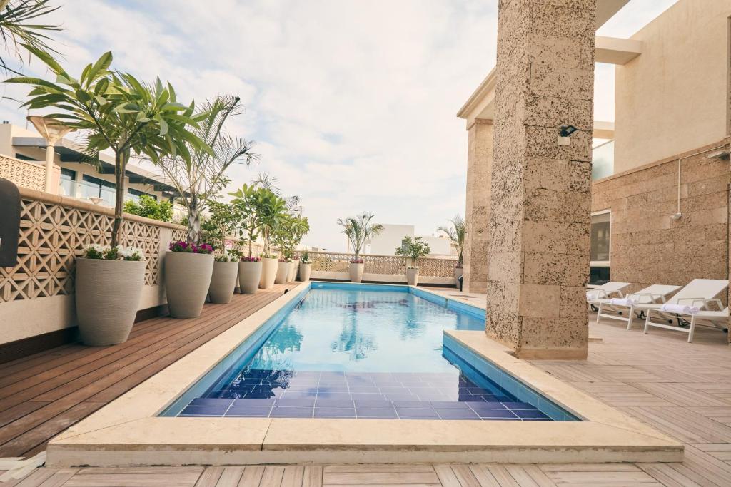 a swimming pool on a balcony with chairs and plants at אריה במדבר - וילה מושלמת עם בריכה פרטית מחוממת באילת in Eilat