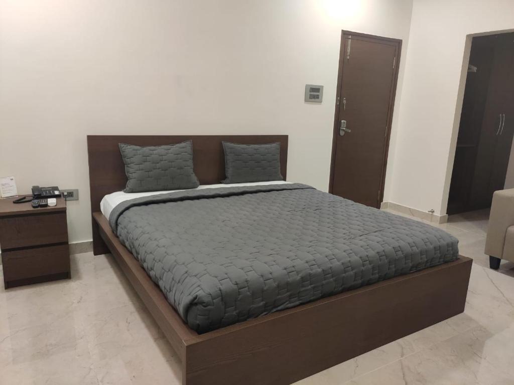 - une chambre avec un grand lit et un cadre en bois dans l'établissement Gachibowli, Santoshi Krupa, à Hyderabad