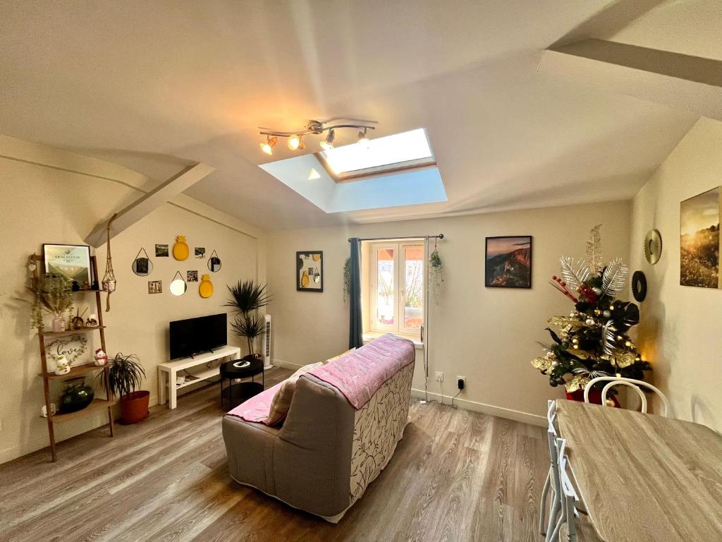 ein Wohnzimmer mit Sofa und Fernseher in der Unterkunft Le Repaire Gîte 2 couchages au calme in Rives