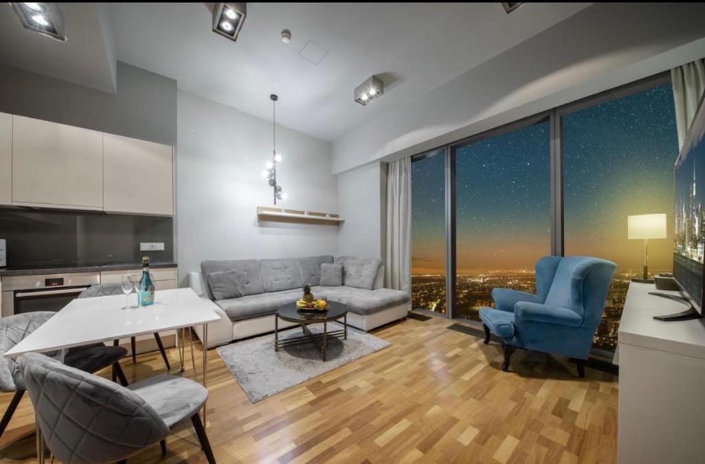 a living room with a couch and a table and chairs at Hanza Tower CITY 19 SPA & Pool & Jacuzzi & Sauna in Szczecin