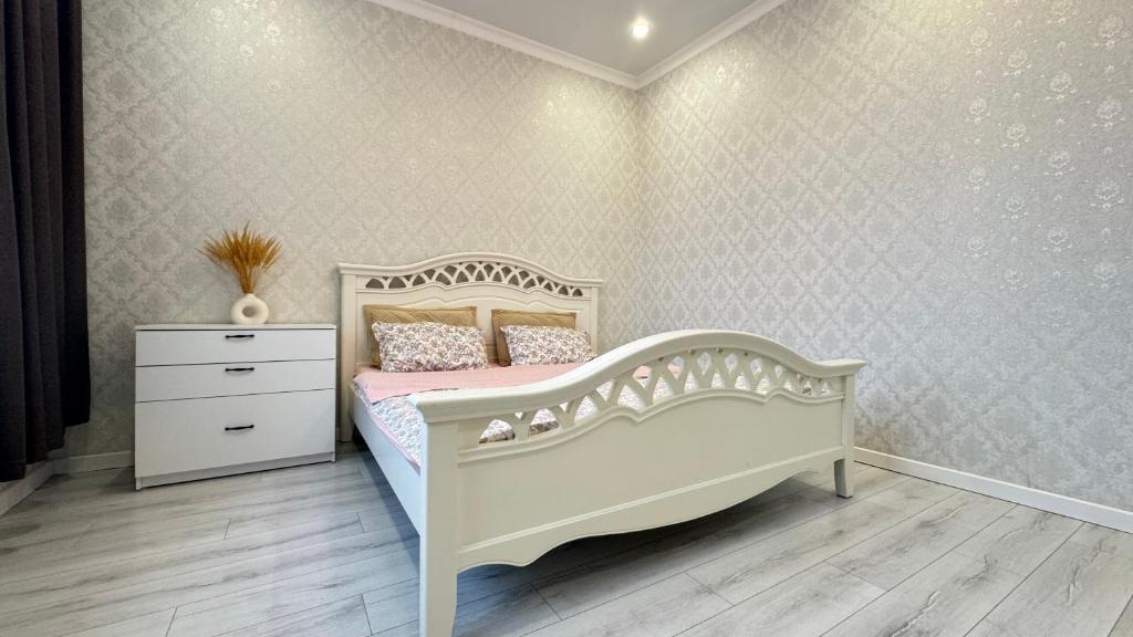 a bedroom with a white bed and a dresser at Expo New Life Astana in Astana