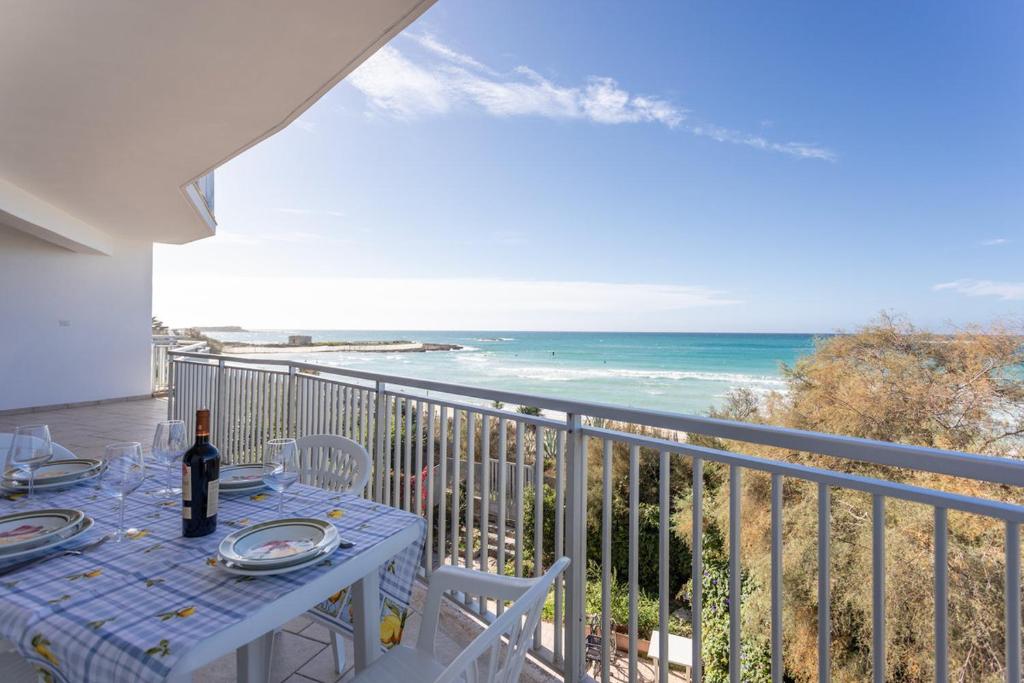 een tafel op een balkon met uitzicht op de oceaan bij Apt Grecale e Ponente vista mare - Salento Reservation in Isola della Malva
