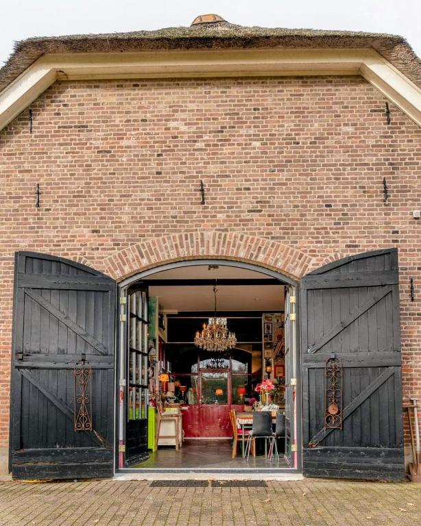 a brick building with two large black doors at Op Vakantie bij Nicole in Putten