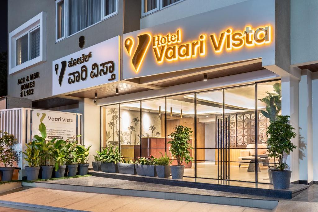a store front of a hotel vittoria with potted plants at Hotel Vaari Vista By Bestinn Leisure in Bengaluru