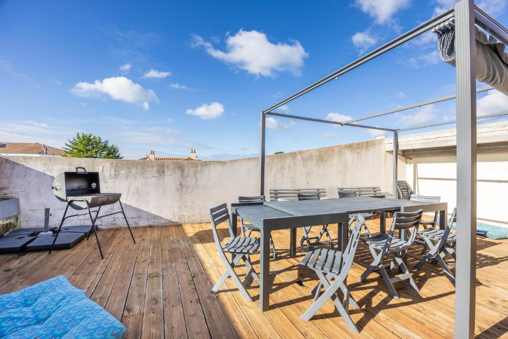 滨海布朗22 couchages centre de Brem的露台上有一张桌子和几把椅子