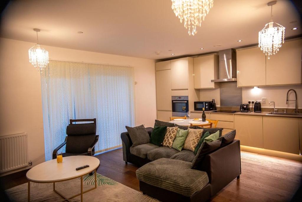 ein Wohnzimmer mit Couch und Tisch und eine Küche in der Unterkunft Stylish Kent apartment in Maidstone
