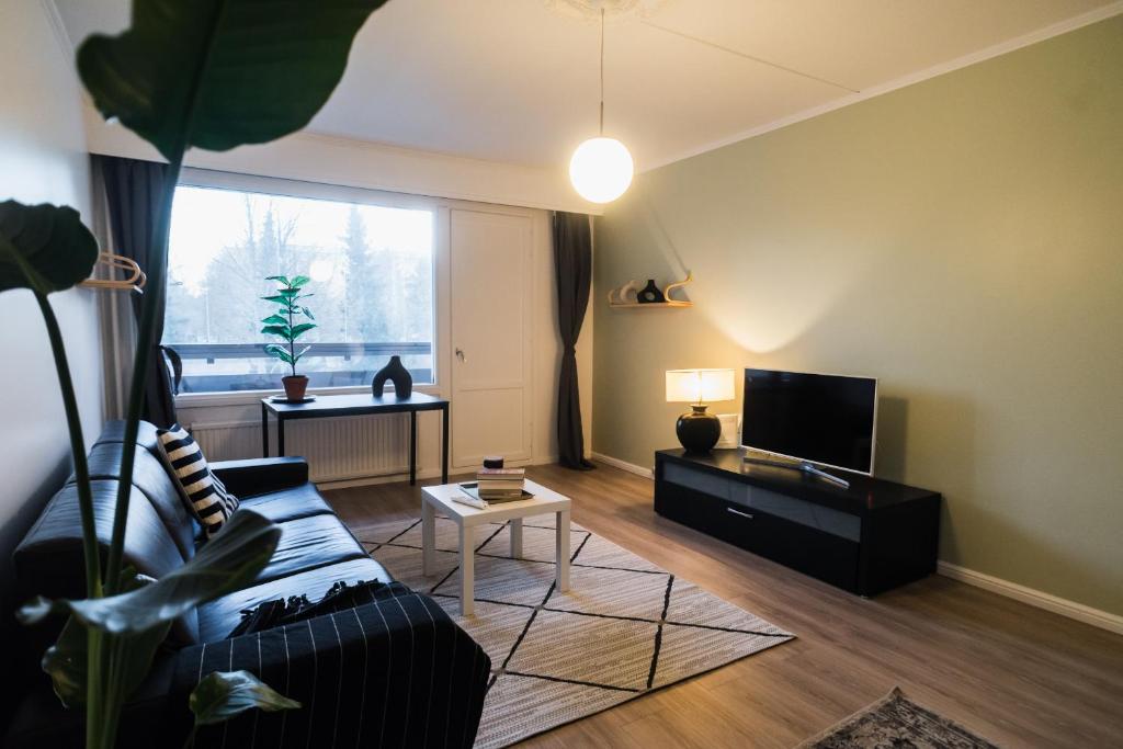 ein Wohnzimmer mit Sofa und Fernseher in der Unterkunft Renovated 60m2 flat & free parking, balcony, Wifi in Pori