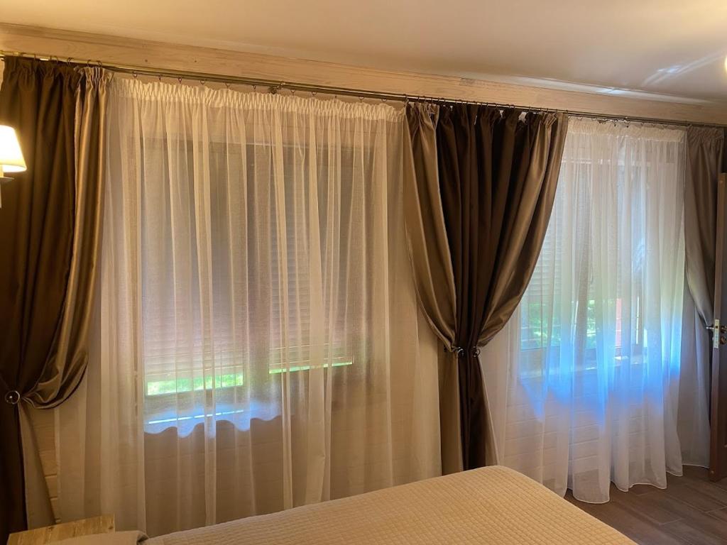 a bedroom with a bed and a window with curtains at Котедж GLORIA будинок повністю in Yaremche