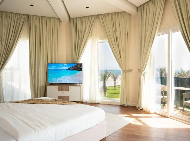 1 dormitorio con 1 cama grande y TV. en Dana Beach Resort, en Al Sharqiyah