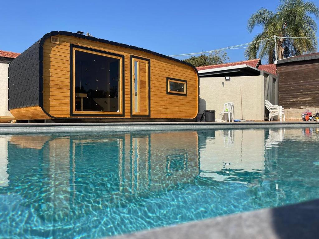 ein kleines Haus neben einem Swimmingpool in der Unterkunft בקתות ההוד in Kallanit