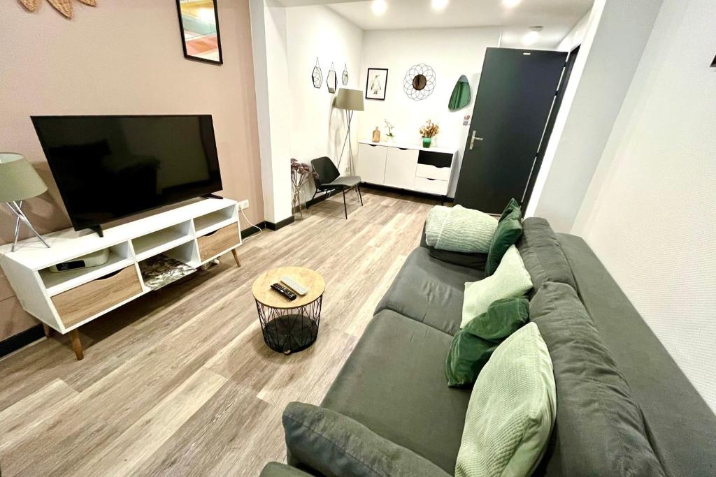 een woonkamer met een bank en een flatscreen-tv bij Le Petit Frontalier in Terville