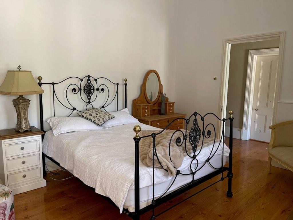 a bedroom with a black and white bed and a chair at The Gilded Hare in Moonta in Moonta