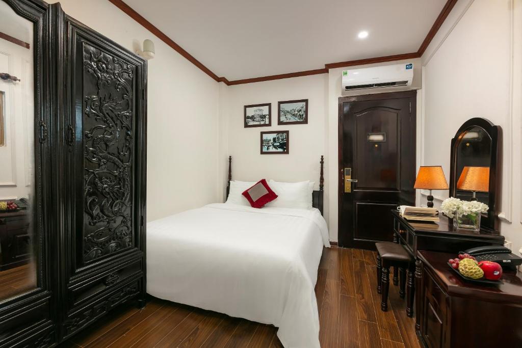 a bedroom with a white bed and a desk at Cat & laundry hotel in Hanoi
