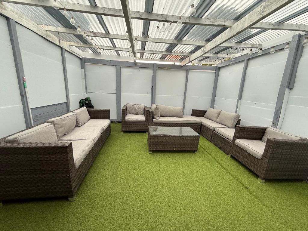 a large room with couches and tables and windows at 2-bed granny flat near Auckland Airport in Auckland