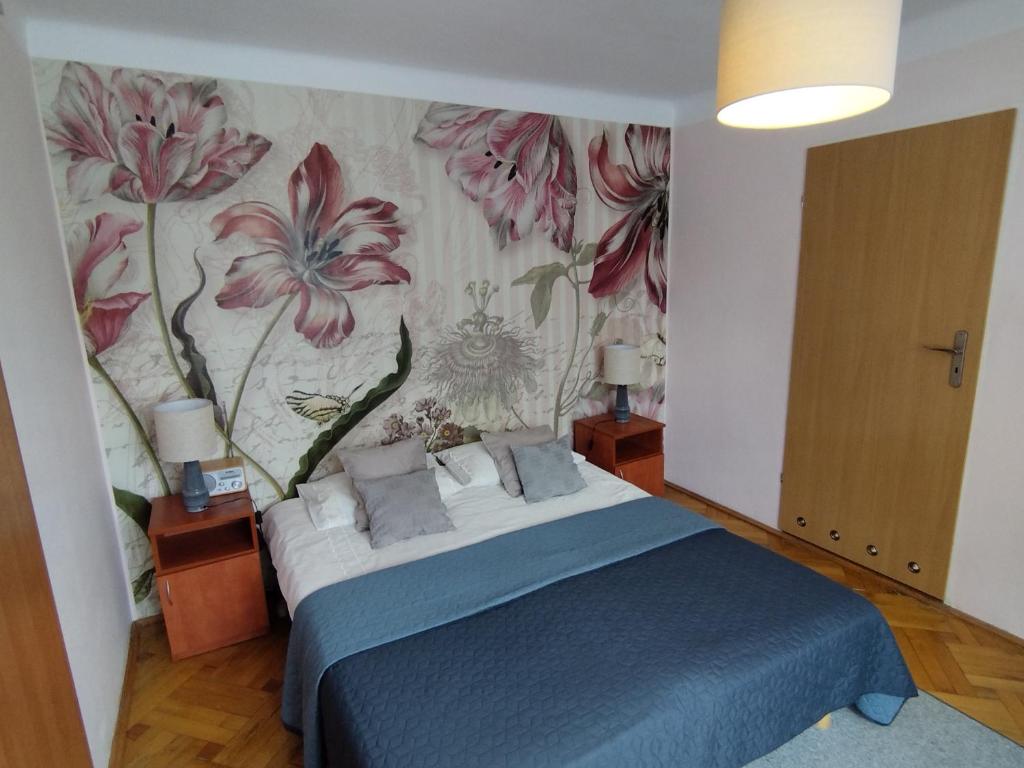 a bedroom with a bed with a floral wallpaper at Willa Anna in Nałęczów