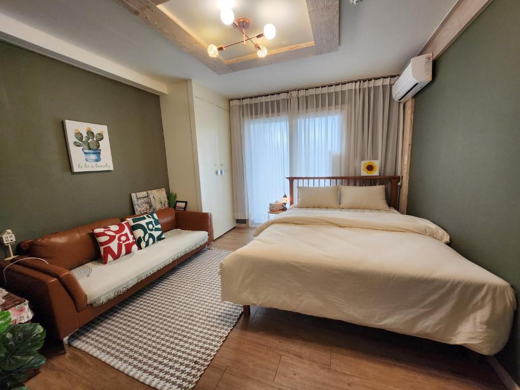a bedroom with a large bed and a couch at sunset in Hyoja-dong