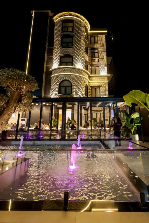 a hotel with a fountain in front of a building at Si'Hana Hotel in Elbasan