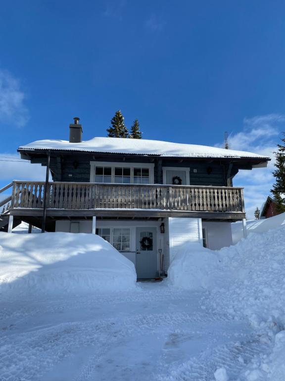 Sälen Gruvens fäbod في سالن: منزل مغطى بالثلج مع كومة من الثلج