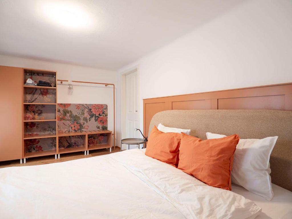a bedroom with a large bed with orange pillows at Historisches Schiffmeisterhaus im Zentrum in Melk