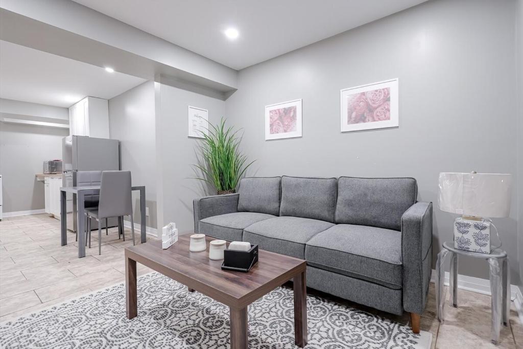 ein Wohnzimmer mit Sofa und Tisch in der Unterkunft Renovated 2 Bedroom Basement Apartment Near 401 and Amenities in Bowmanville