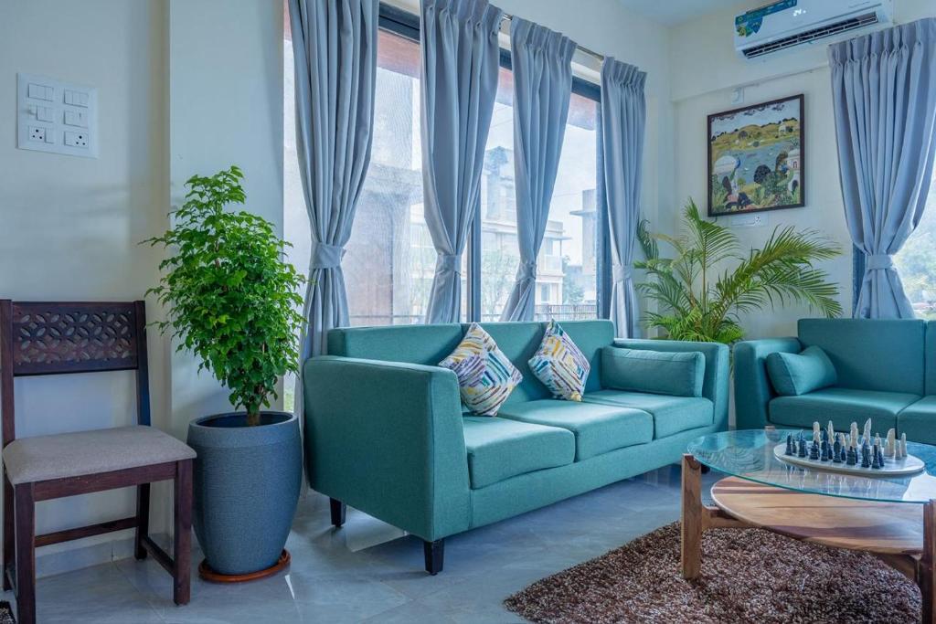 a living room with a blue couch and a table at Villa 29 - 3BHK Villa with Private Pool in Khopoli in Pali