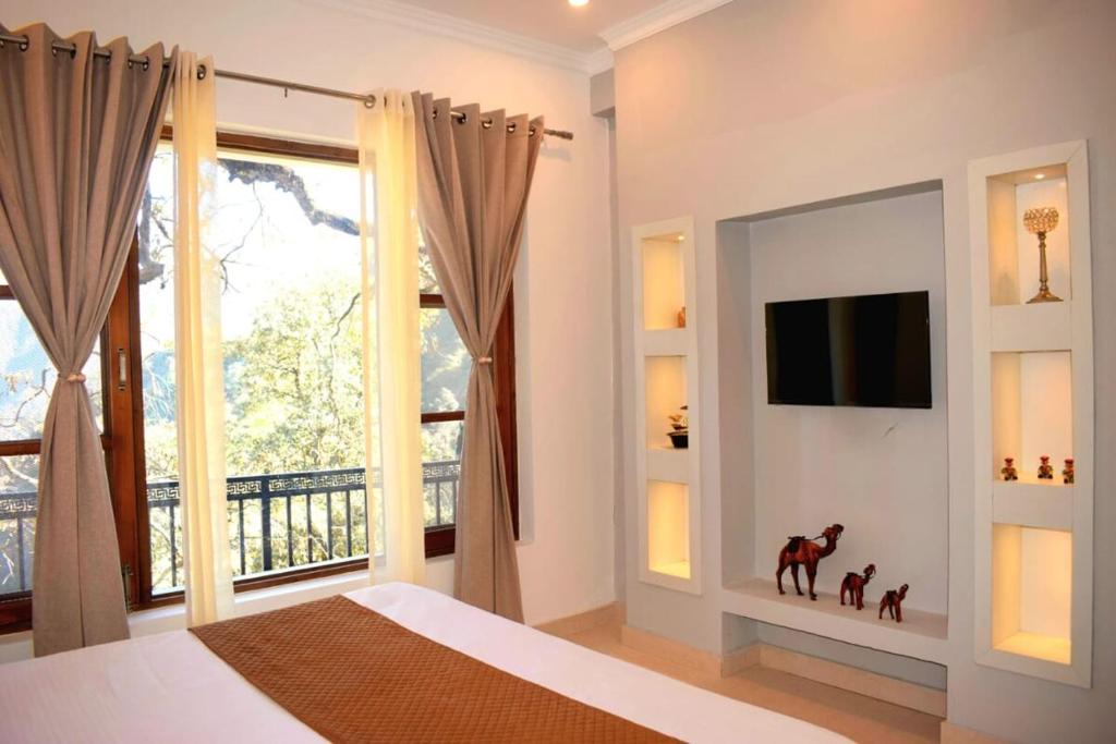 una camera da letto con un letto, una tv e una finestra di Sarins Mistville 4BHK Villa Mall Road a Mussoorie