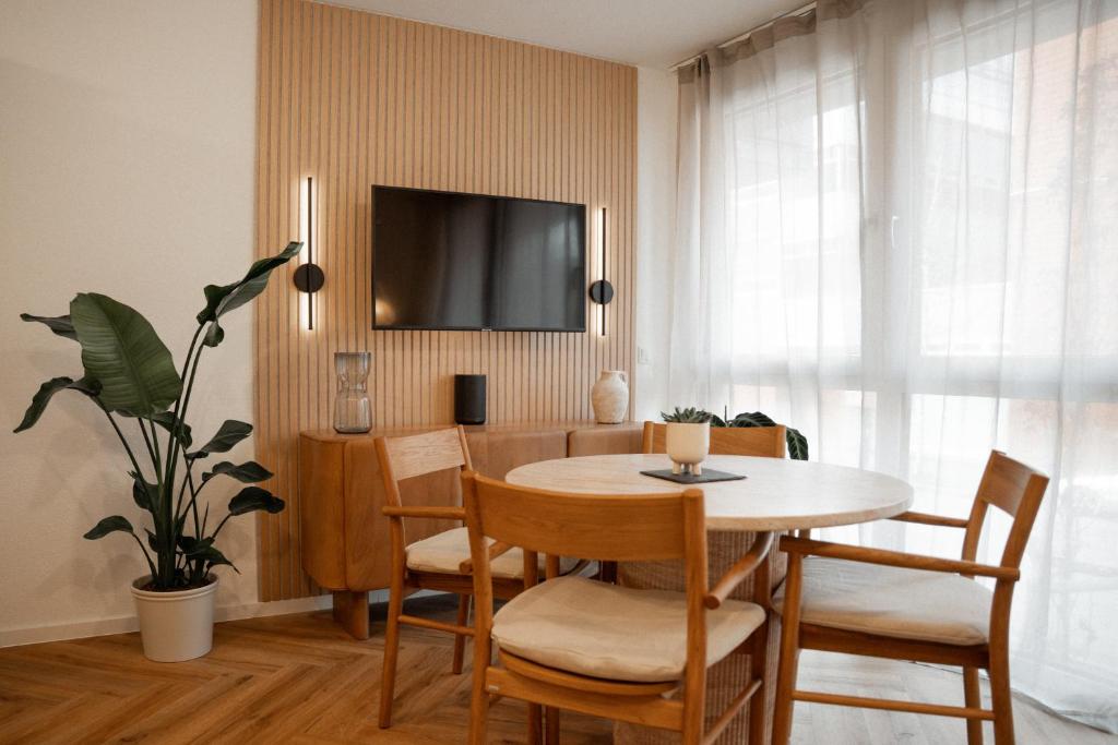 ein Esszimmer mit Tisch und Stühlen und einem Fernseher in der Unterkunft Riversidesuite-Tuebingen in Tübingen