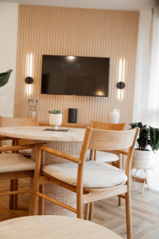 a dining room with a table and chairs and a television at Riversidesuite-Tuebingen in Tübingen