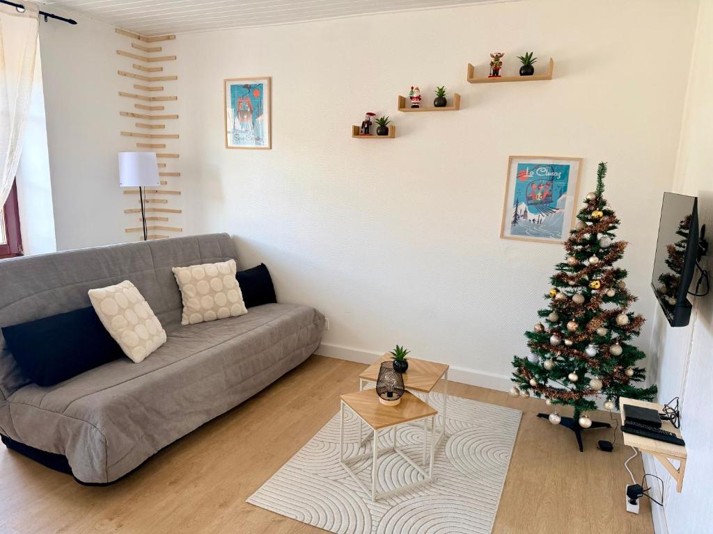 a living room with a christmas tree and a couch at Très bel appartement à 20 min de Gérardmer in Saulcy-sur-Meurthe