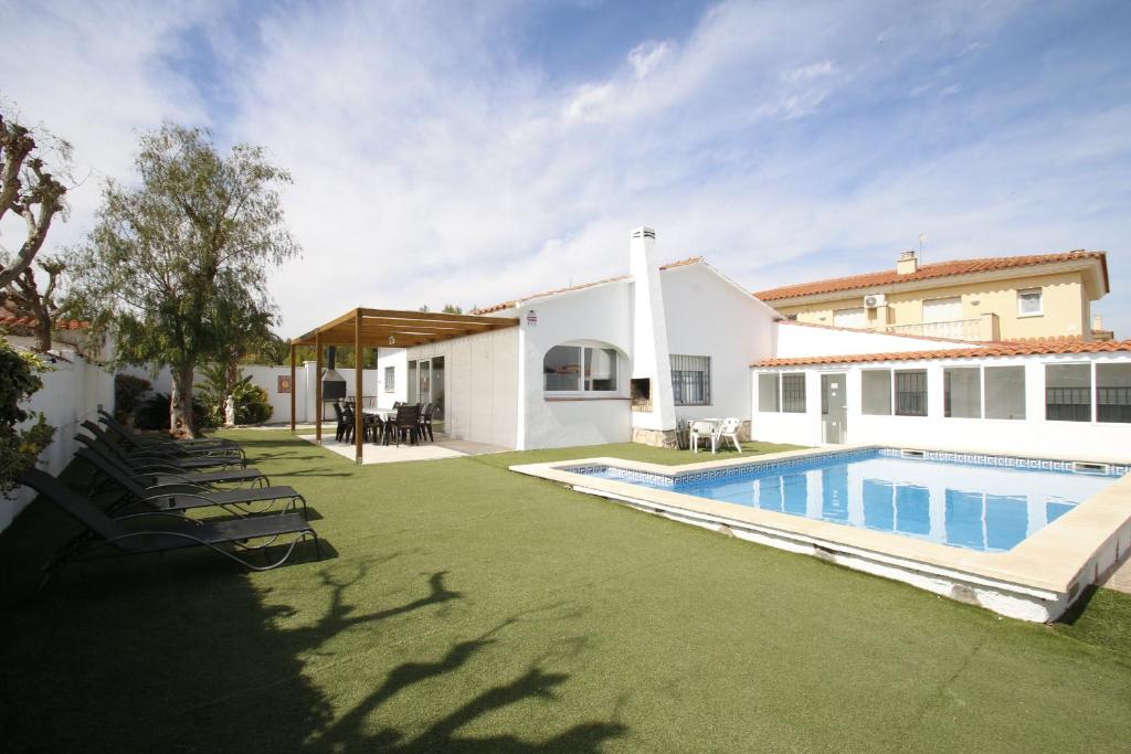 a backyard with a swimming pool and a house at Villa Atenea in Miami Platja