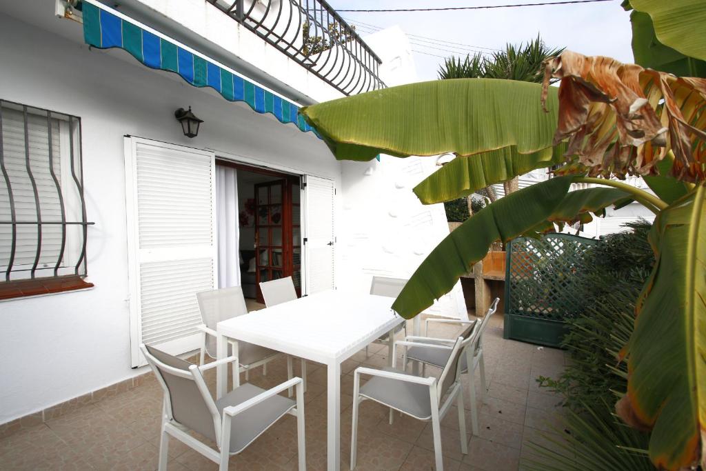 een witte tafel en stoelen op een patio bij Las Marinas A in Miami Platja