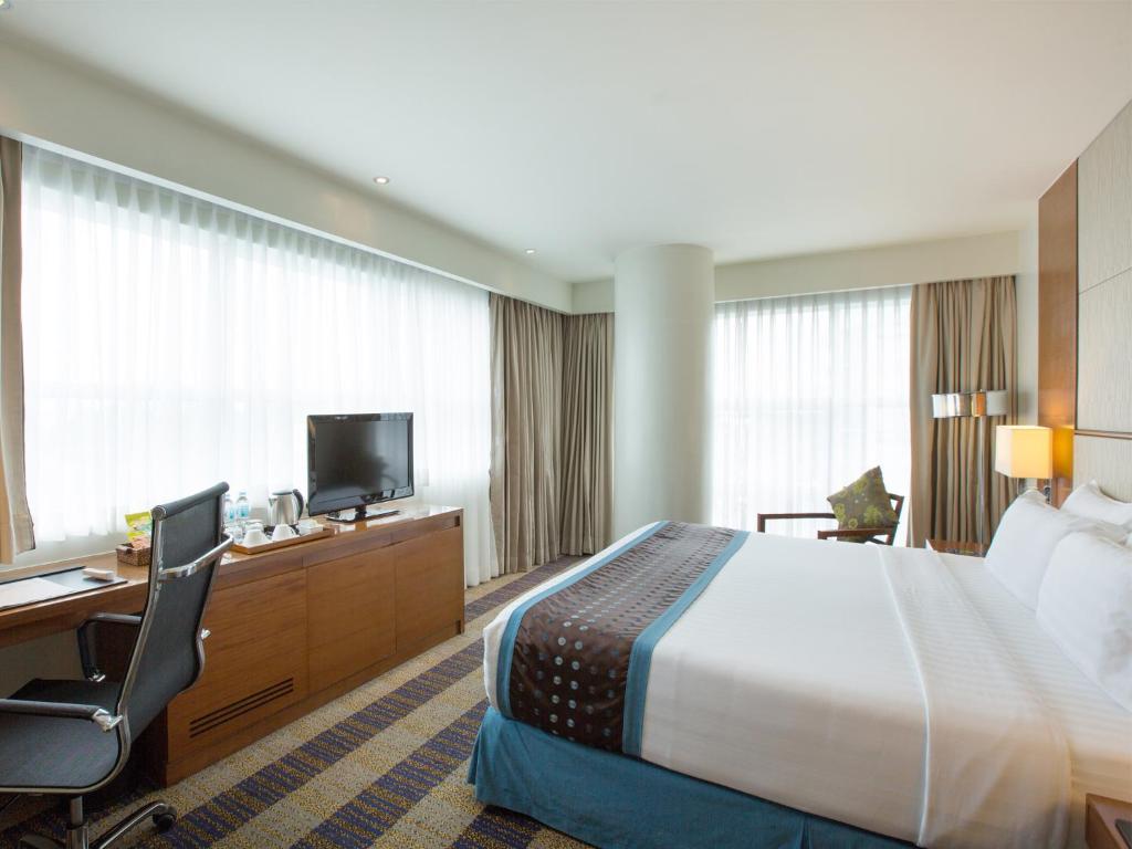 セブシティにあるLex Hotel Cebuのベッド、デスク、テレビが備わるホテルルームです。