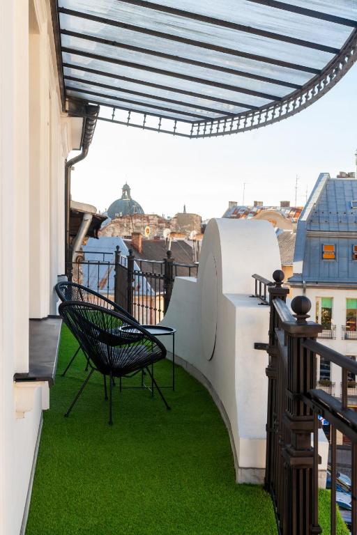 a patio with a table and chairs on a balcony at AUSTRIAN APART HOTEL in Lviv