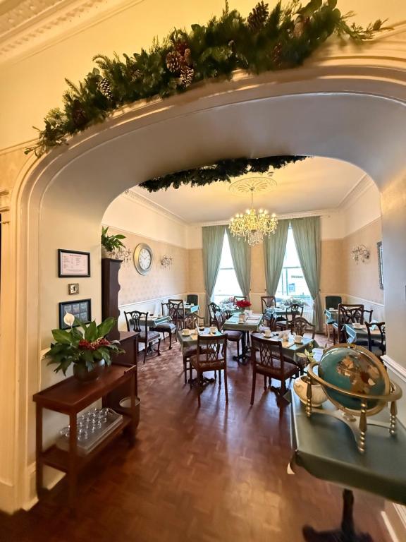 ein Esszimmer mit Tischen und Stühlen und einem Kronleuchter in der Unterkunft The Angove - Adults Only in Weymouth