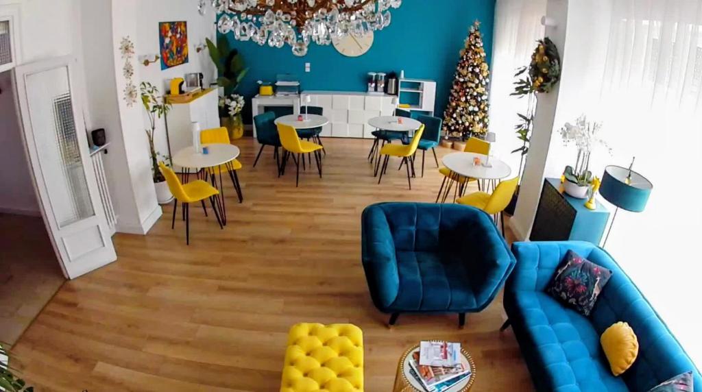 un soggiorno con un divano blu e sedie gialle di B&B Be Home a Palermo