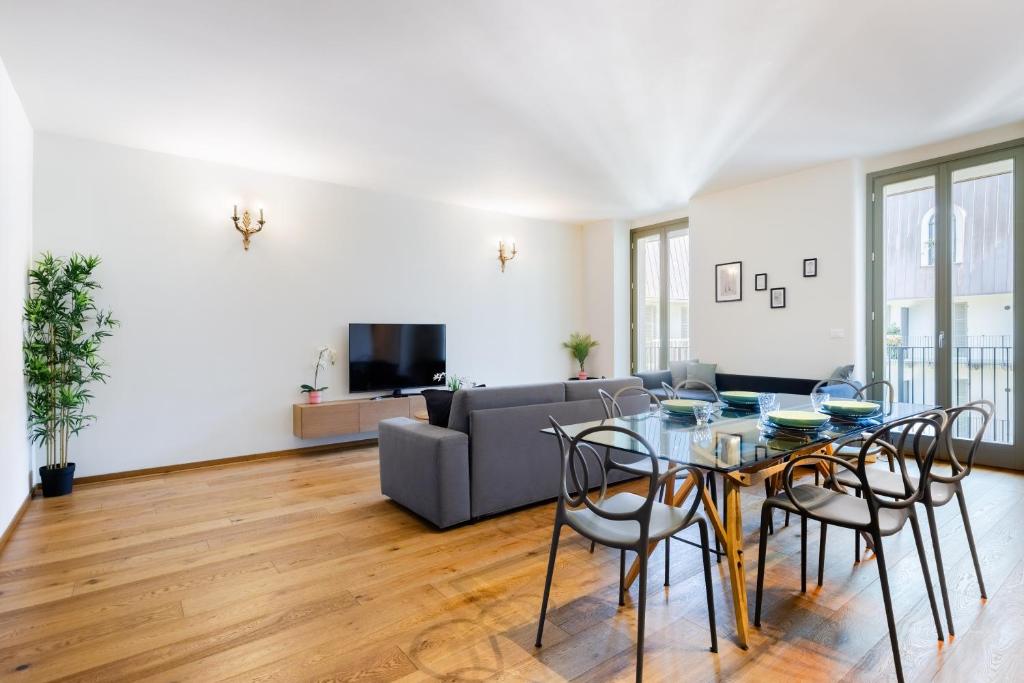ein Wohnzimmer mit Tisch und Stühlen und einer Couch in der Unterkunft Hostdomus - Lagrange Luxury Apartment in Turin