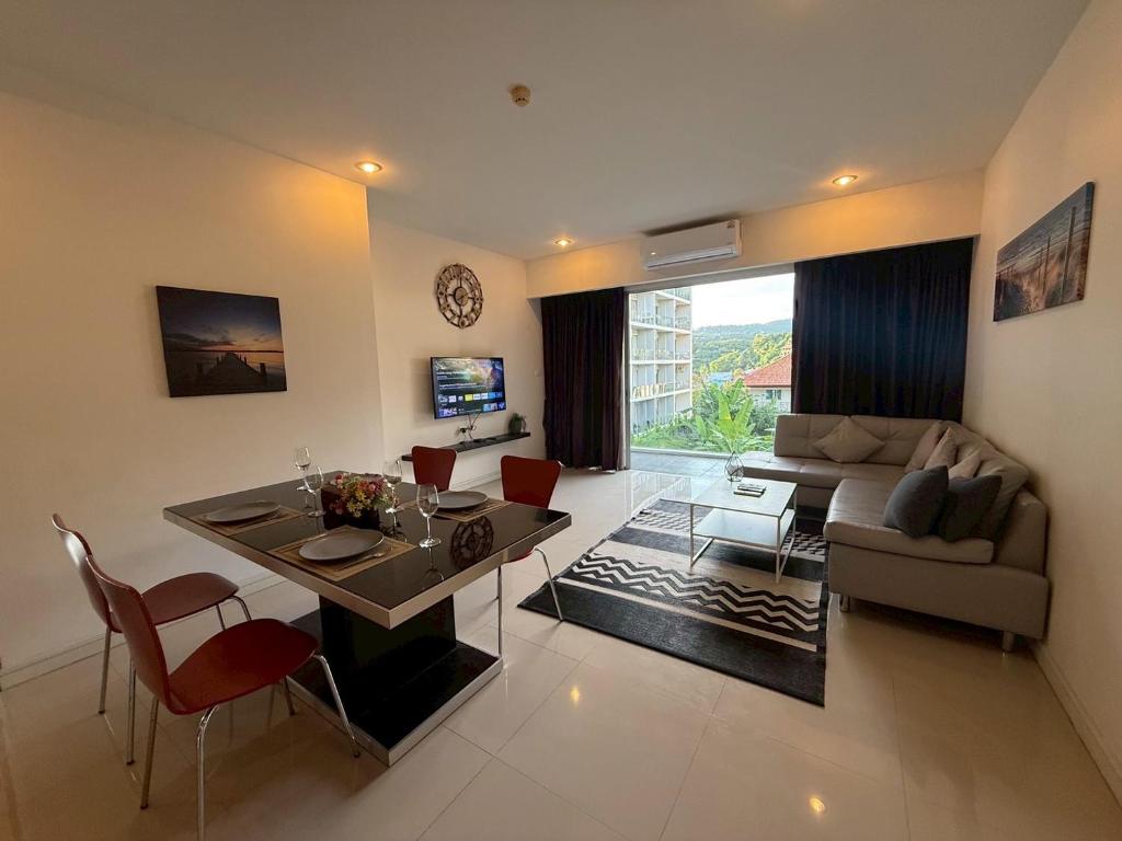 ein Wohnzimmer mit einer Couch und einem Tisch und Stühlen in der Unterkunft Chic B309 in Ban Nong Chaeng
